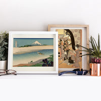 Deux femmes debout, tenant de petites boîtes d'un jeu de loterie, avec un homme à genoux entre eux